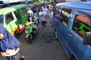 Runners race between public minivans